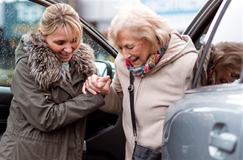 woman helps older woman out of car
