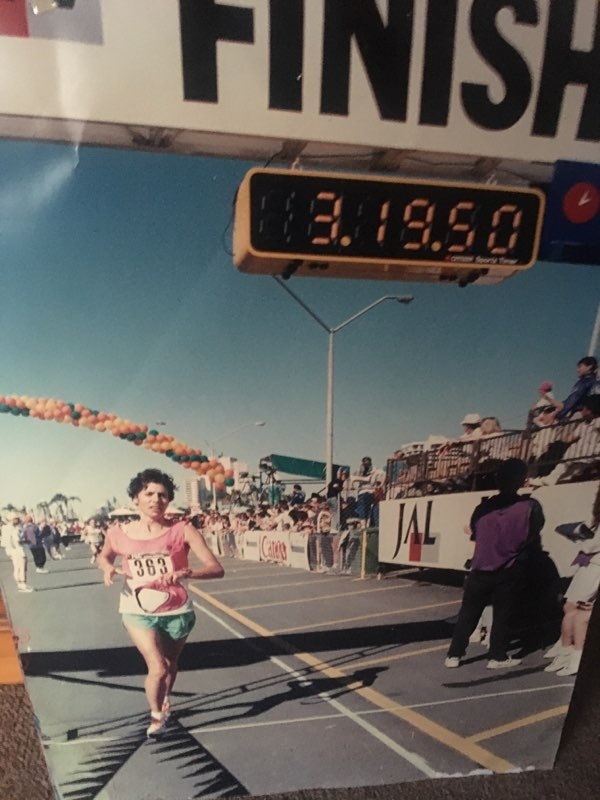 Tina runs across the finish line at the Gold Coast Marathon, with the timer showing3 hours, 19 minutes and 50 seconds.