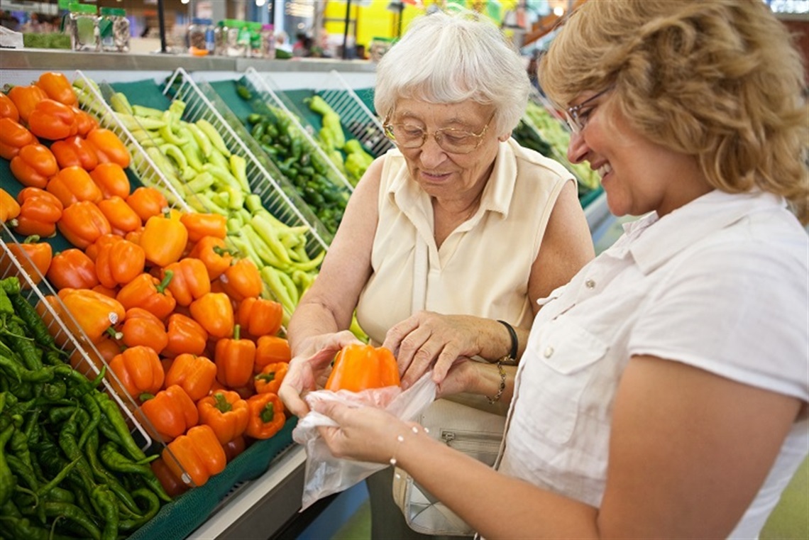 aged person assisted shopping for fresh food