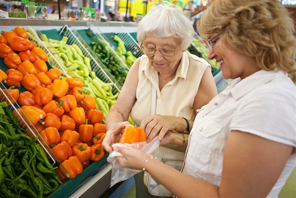 aged person assisted shopping for fresh food