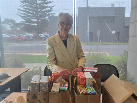 Lady delivering music devices stadning in office. 