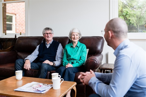 Two AccessCare client chat to their case manager in their living room.