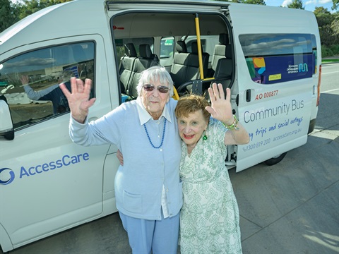 Ruth and Lilian waving at the front of the bus