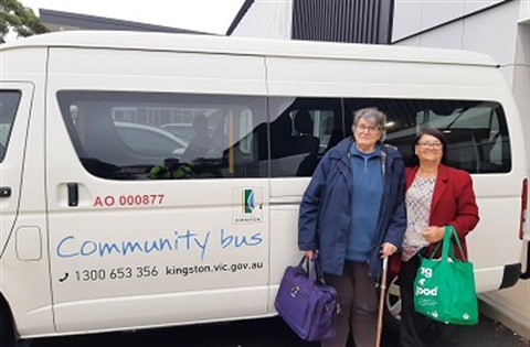 Two AccessCare clients stand in front of the community bus out the front of the Danny Frawley Centre.