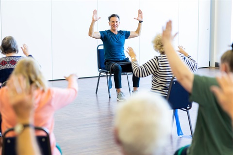 A fitness instructor leads a seniors exercise class.