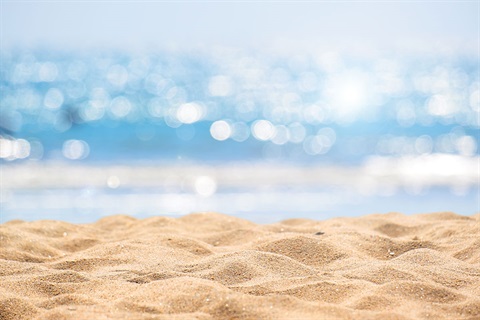 A sandy stretch of beach heats up under a hot sun