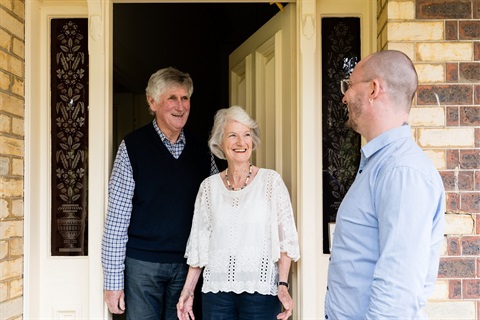 Two AccessCare clients greet their case manager at their front door.