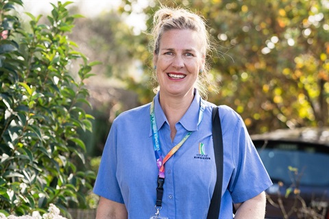 AccessCare support worker smiles as she arrives at a client's home.