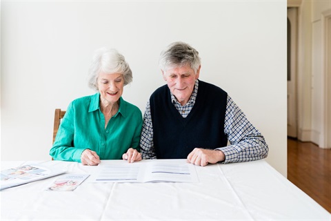 A older couple looks over AccessCare brochures 