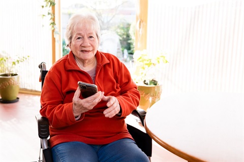 Older woman uses her mobile phone to access her service schedule.
